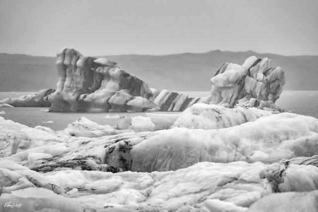 Black and white photograph of layered ice formations floating in Jökulsárlón Glacier Lagoon Iceland.