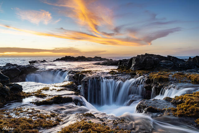Ocean water cascading through lava rocks at sunset in Kona Hawaii.