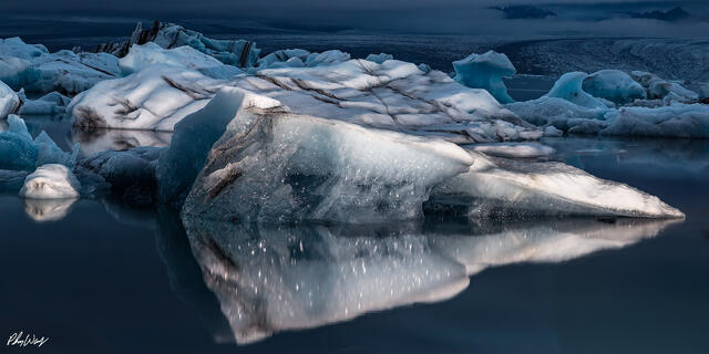 Iceberg reflecting in dark blue water at Jökulsárlón Glacier Lagoon in Iceland.