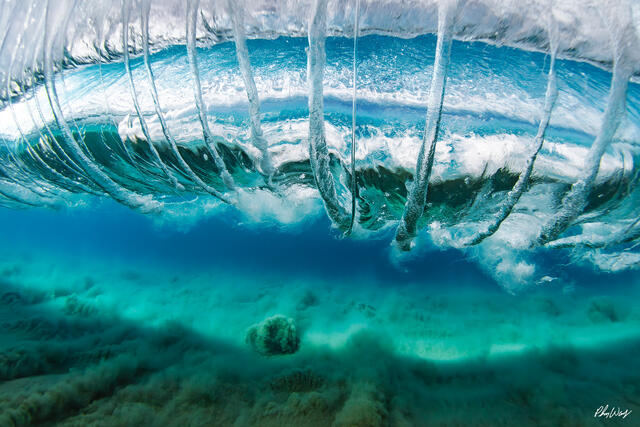 Underwater view of a breaking wave forming vortex lines beneath the surface on the North Shore of Oahu Hawaii.