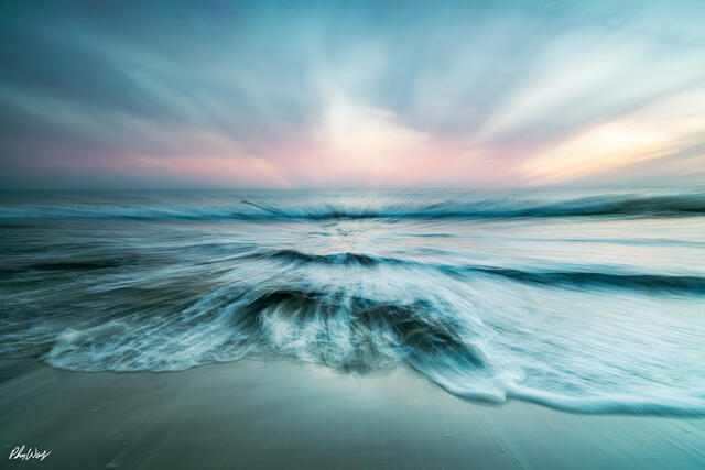 Abstract motion blur of ocean waves rushing toward shore at sunset on the Kona coast, Big Island of Hawaii.