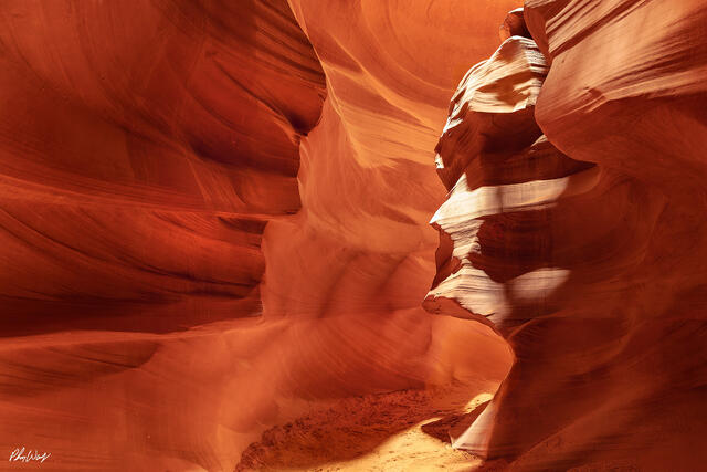 Sandstone formations resembling faces inside Antelope Canyon Arizona with warm red light.