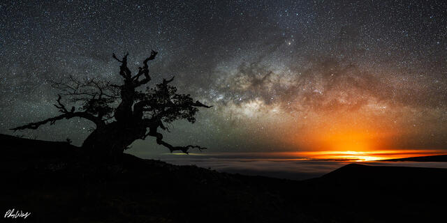 Milky Way over Mauna Kea with the distant glow of Kilauea lava on the Big Island of Hawaii.
