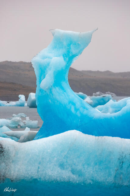 Blue sculpted iceberg floating in Jökulsárlón Glacier Lagoon Iceland.