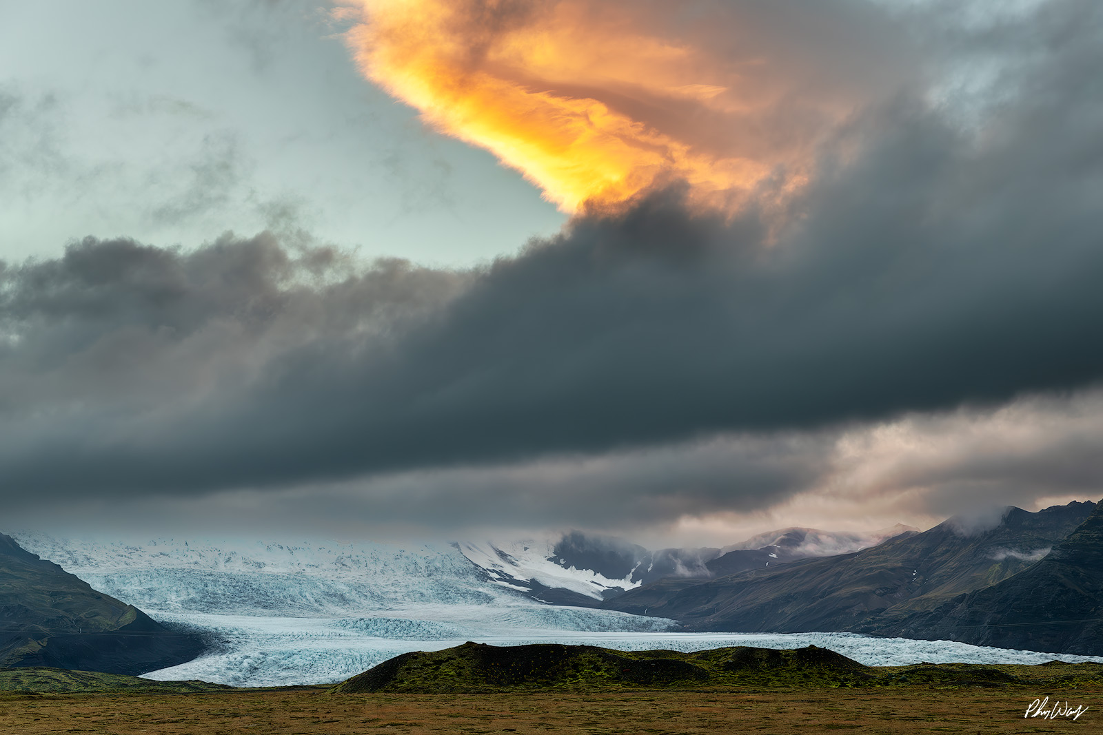Glowy Iceland Glowing storm clouds over glacier and mountains near Haifoss Iceland.
