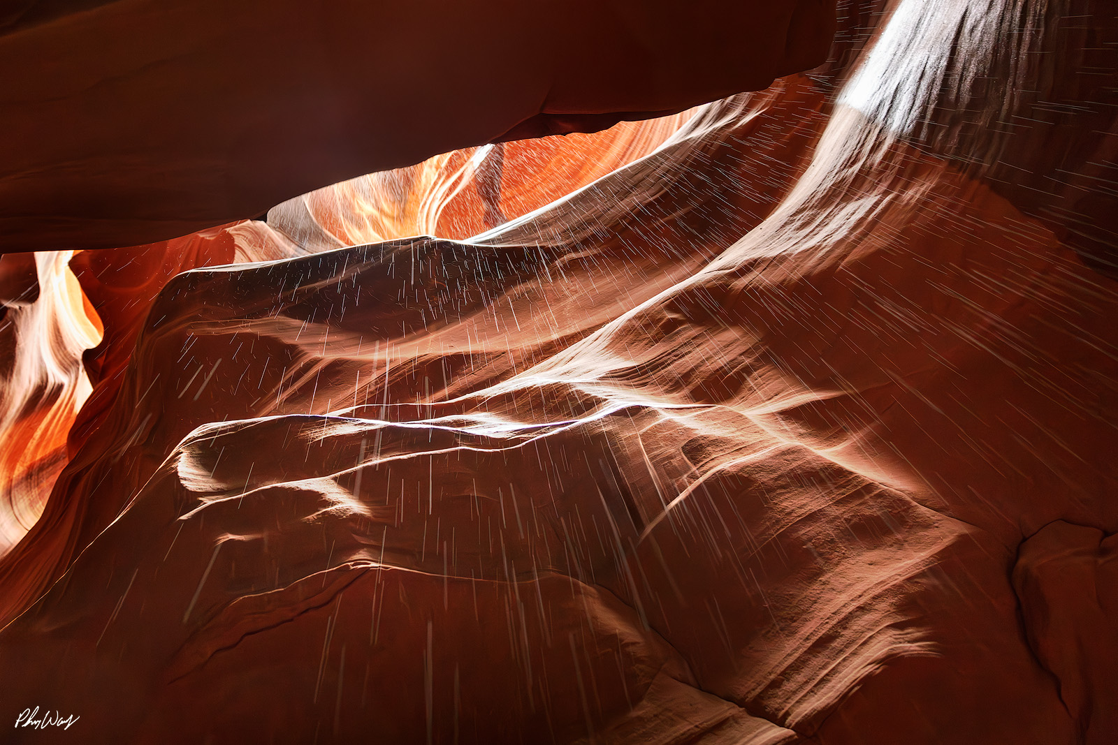Antelope Tears Light beams and falling sand inside Antelope Canyon creating streaks across smooth sandstone walls.