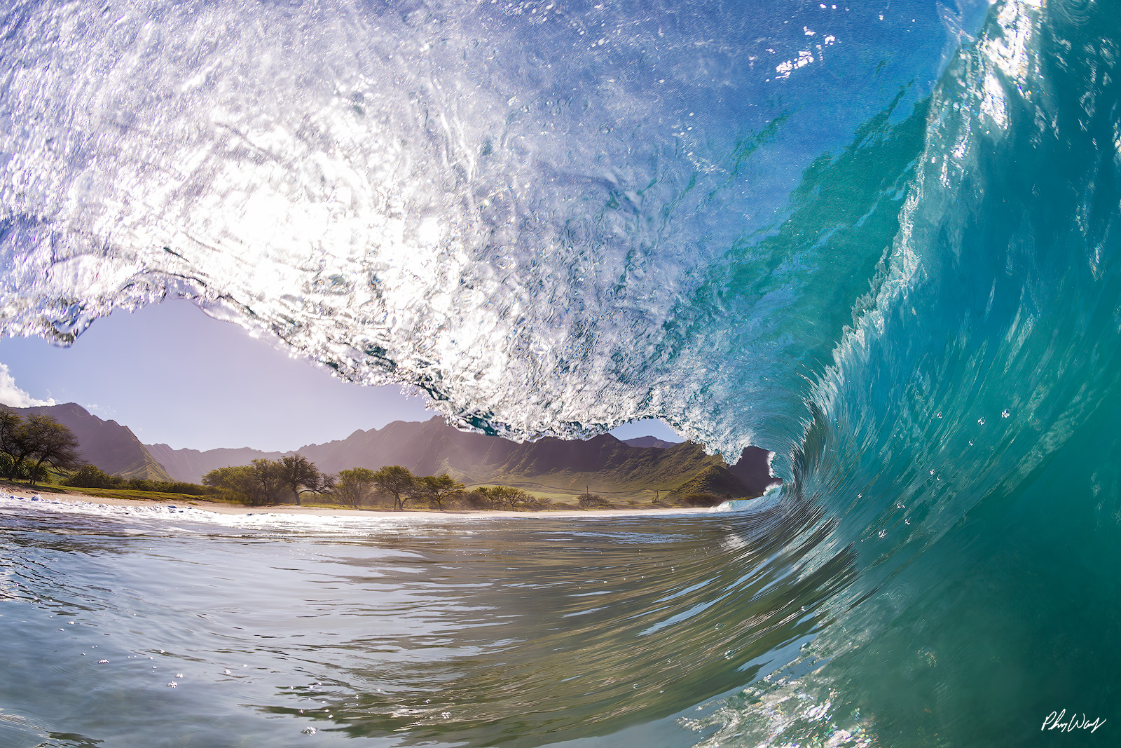 Dream Curl Hawaii Turquoise ocean wave curling near a tropical beach with mountains in Oahu Hawaii.