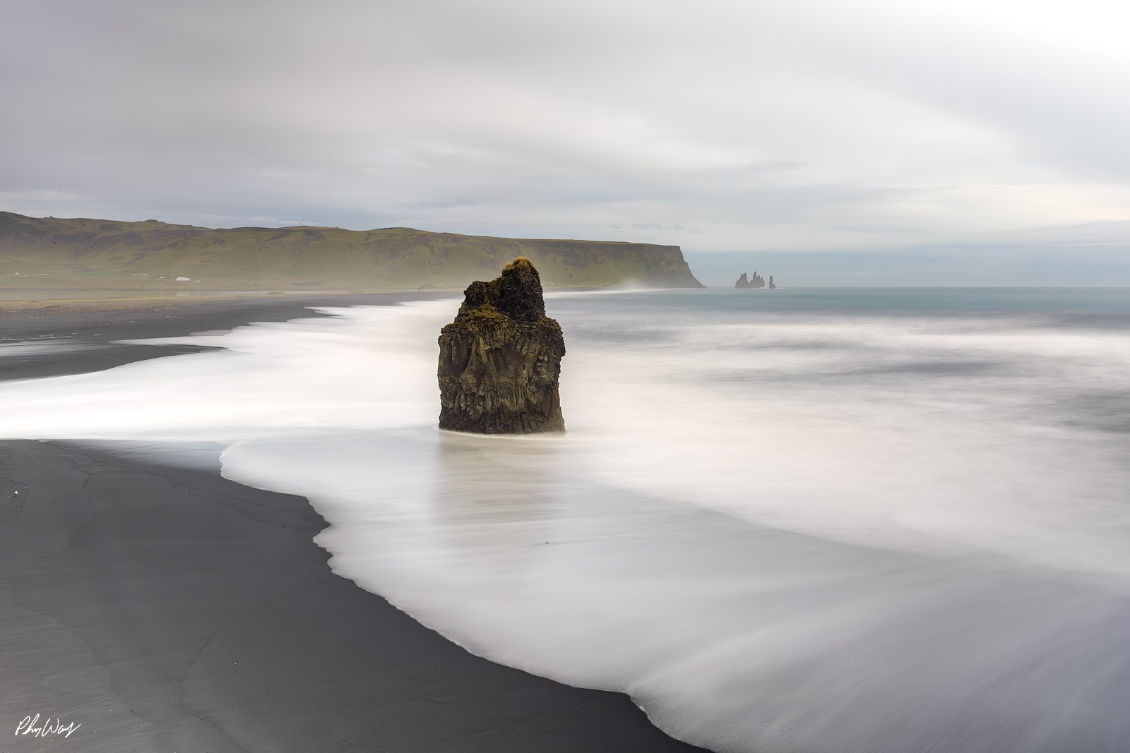 Coastal Exposure Long exposure ocean waves surrounding a sea stack on Reynisfjara Beach in Iceland.