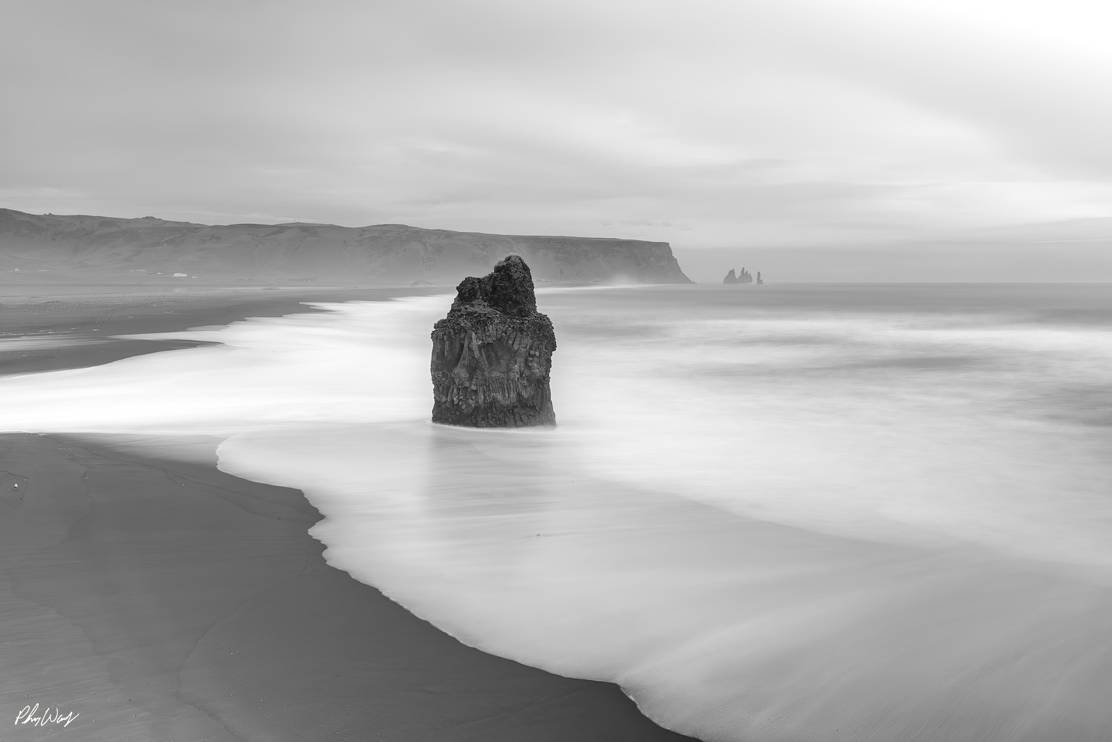 Coastal Exposure Black and white long exposure photograph of a sea stack on Black Sand Beach in Iceland.