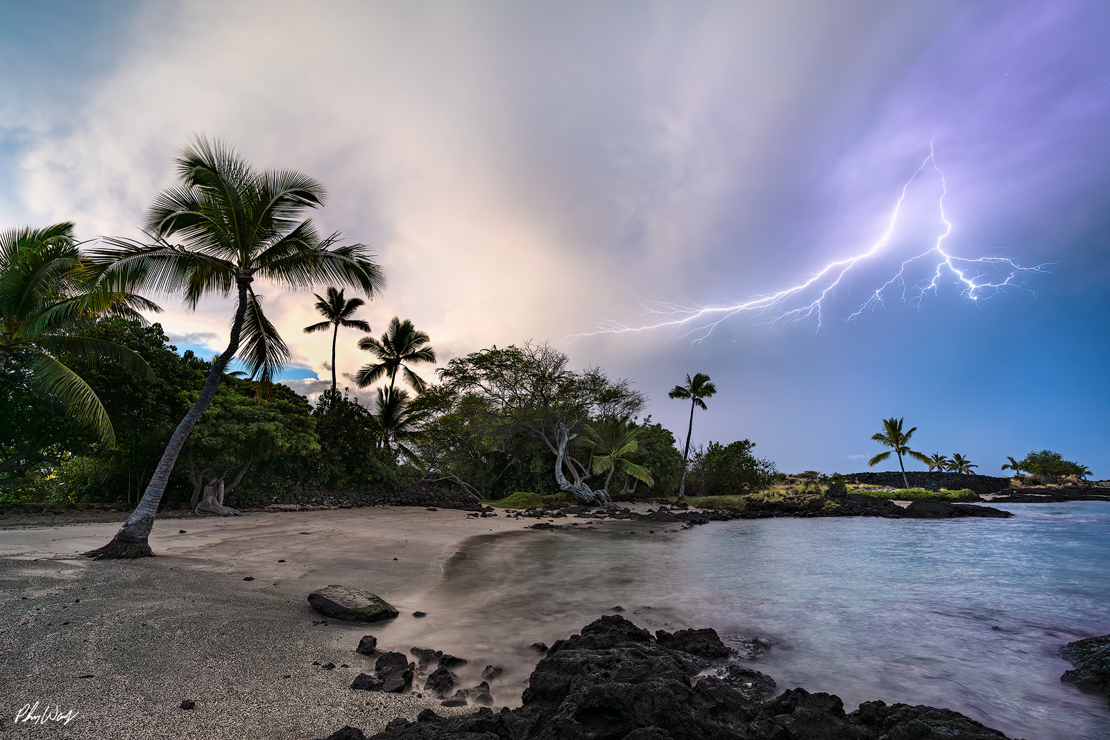 Kona Lightning Storm Lightning striking over a tropical beach with palm trees in Kona Hawaii.