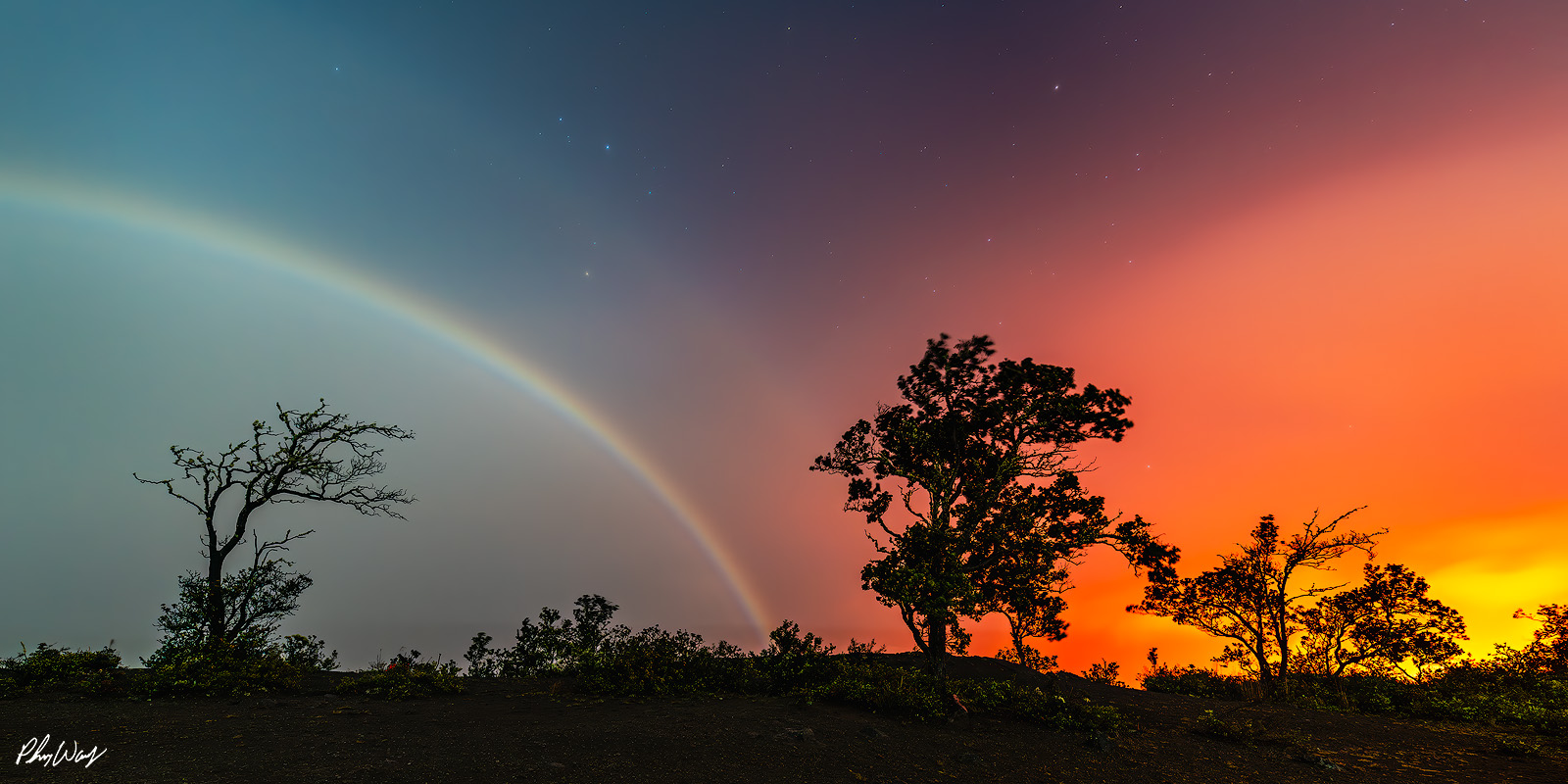 Lava Moonbow Combination Lunar rainbow over volcanic landscape with lava glow at night in Volcano National Park on the Big Island of Hawaii.
