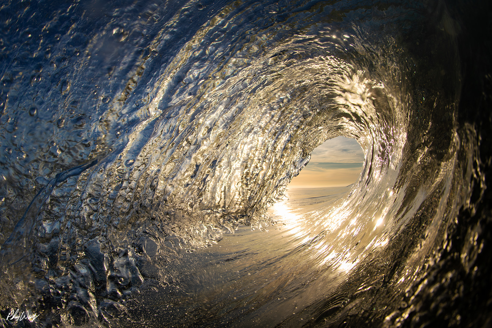 Zuma Sunrise Barrel Sunrise light shining through a curling ocean wave at Zuma Beach in Malibu, California.