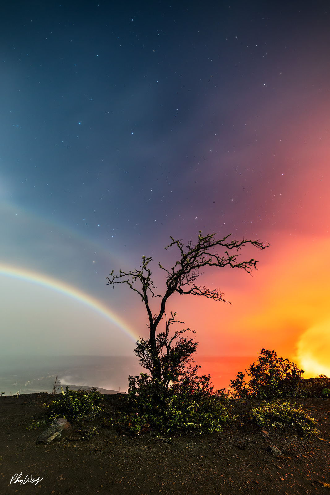 Moonbow and Lava Mixture Moonbow arching over glowing lava with silhouetted tree at Volcano National Park on the Big Island of Hawaii.