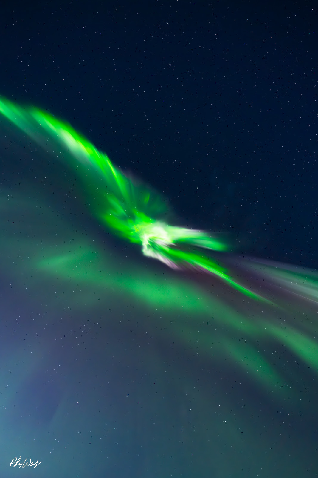 Sky Magic Aurora Green aurora borealis flowing across a dark star filled sky over Reykjavik, Iceland.